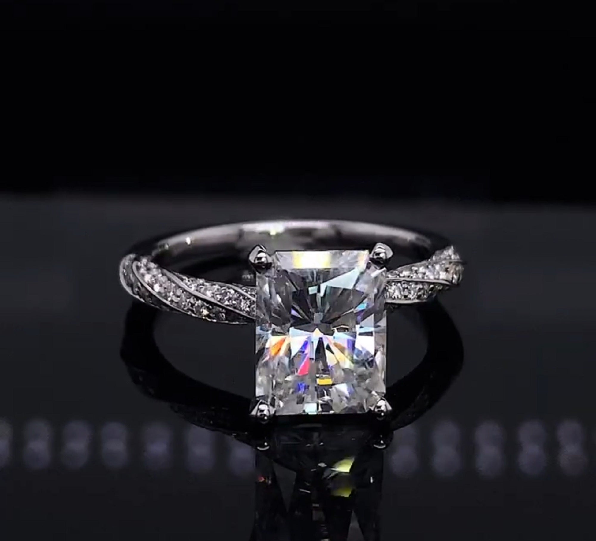 Straight-on view showing the fiery brilliance of a 3 carat elongated radiant lab diamond on a braided diamond-encrusted band.