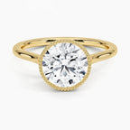 Top-down view of a yellow gold engagement ring featuring a 3 CT round brilliant lab diamond surrounded by a milgrain rim