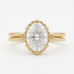 Top-down view of a 3 CT oval cut lab grown diamond engagement ring framed by a scalloped bezel on a yellow gold double band.