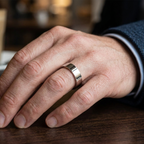 On-hand view of a men's classic flat profile wedding band with a high-polish mirror finish.