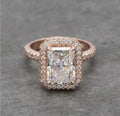Direct top view of a 4 CT radiant cut lab grown diamond halo engagement ring in rose gold with a multi-row pavé band.