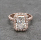 Direct top view of a 4 CT radiant cut lab grown diamond halo engagement ring in rose gold with a multi-row pavé band.