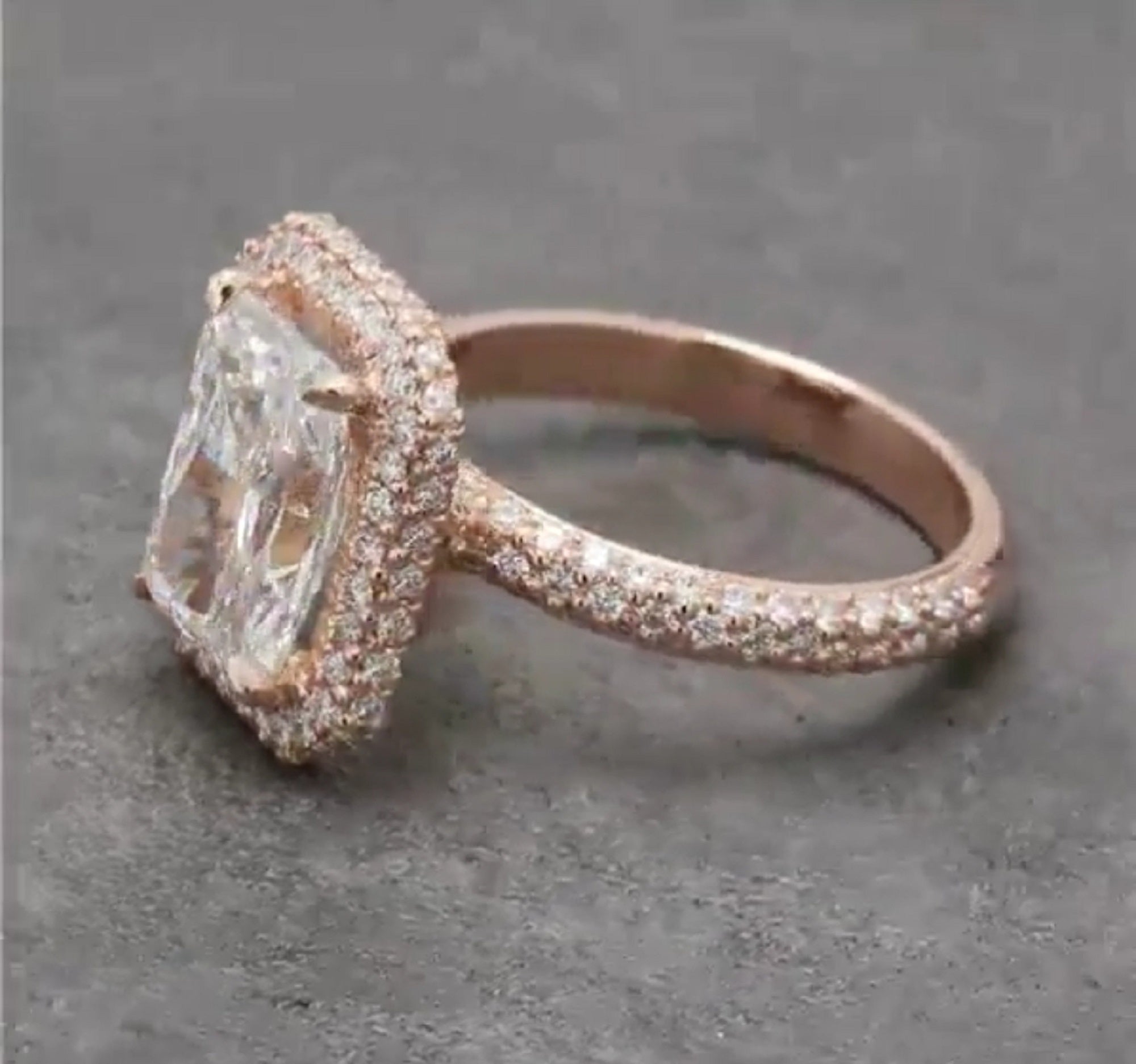 Three-quarter view highlighting the multi-row diamond encrusted band and prominent rose gold radiant halo setting.