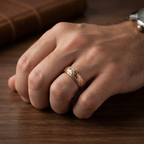 Lifestyle photo of a man wearing a rose gold vintage engraved scrollwork wedding ring on hand