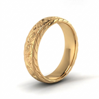 Angled 3/4 view of a men's yellow gold engraved floral scrollwork wedding band