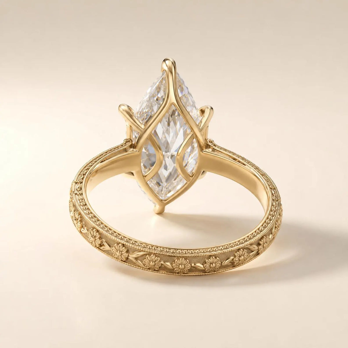 View of the undergallery basket and floral engraved yellow gold band of a 3 CT marquise lab diamond ring.