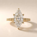 Top-down studio shot of a brilliant 3 CT marquise cut lab grown diamond solitaire ring with floral milgrain band.