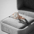 2 carat oval cut lab diamond halo ring with botanical leaf band resting inside a grey velvet jewelry box.