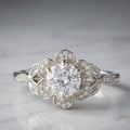 Studio shot of a 3 CT round cut lab grown diamond set in a white gold floral blooming petal halo setting.