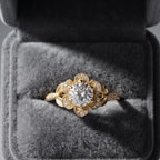 Yellow gold 3 carat round lab diamond floral halo engagement ring in a grey velvet presentation ring box.