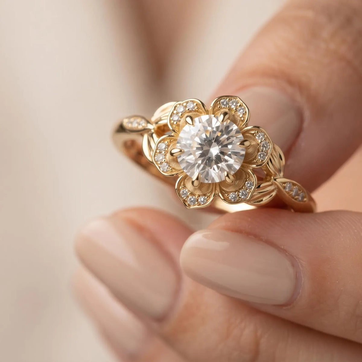 Hand holding a yellow gold 3 CT round lab grown diamond engagement ring highlighting the sculpted flower bloom gallery.
