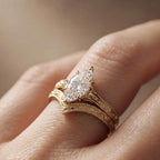 On-hand view of a 2 CT marquise cut lab diamond engagement ring paired with an intricate filigree chevron wedding band.