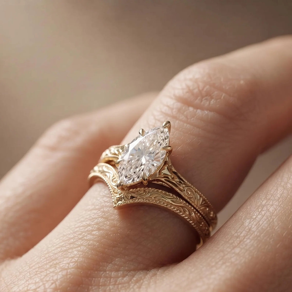 On-hand view of a 2 CT marquise cut lab diamond engagement ring paired with an intricate filigree chevron wedding band.