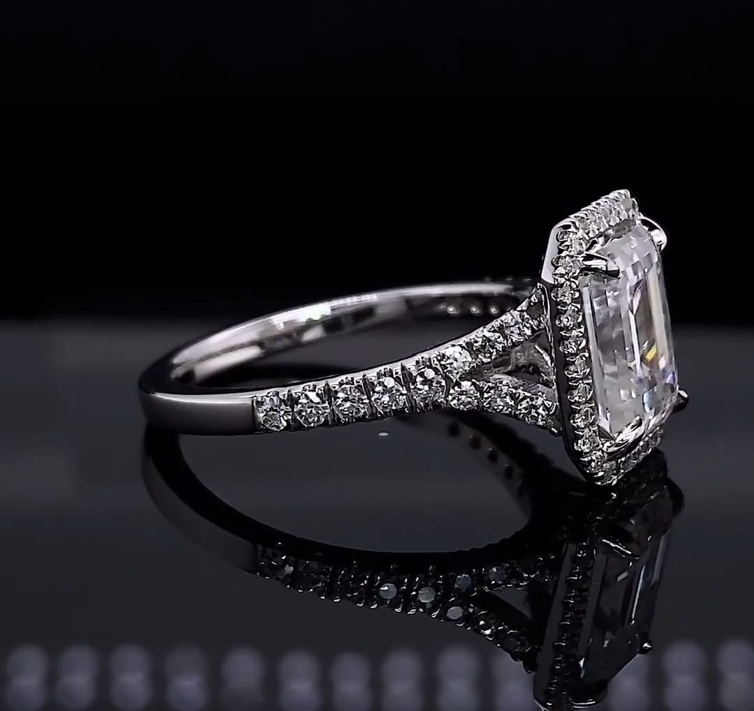 Side profile view showing the diamond-encrusted pavé split shank of a 3 carat emerald cut engagement ring.
