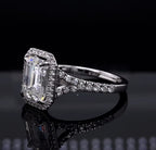 Close-up angled view of a 3 CT emerald cut lab grown diamond ring resting on a reflective black surface.