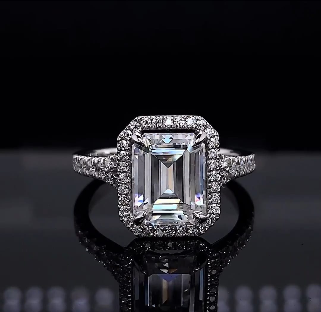 Direct front view of a stunning 3 CT emerald cut lab grown diamond halo engagement ring in white metal.