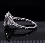 Low angle side view detailing the gallery, prong setting, and pavé diamond split shank of an emerald cut ring.
