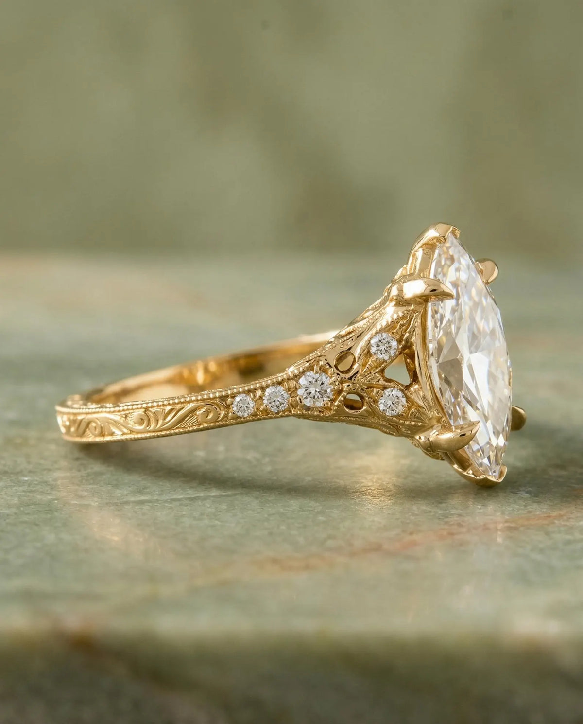Side angle of a 4 carat marquise lab diamond engagement ring featuring cathedral filigree shoulders and engraved scrollwork.