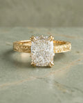 Top-down view of a 3 CT elongated cushion cut lab diamond set in a vintage hand-engraved yellow gold ring with double prongs.