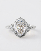 Top view of a 4 CT oval lab grown diamond ring in white gold featuring a vintage scalloped frame and marquise side clusters.
