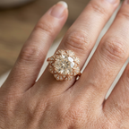 On-hand view of a 4 CT cushion cut lab grown diamond vintage floral halo engagement ring in rose gold.