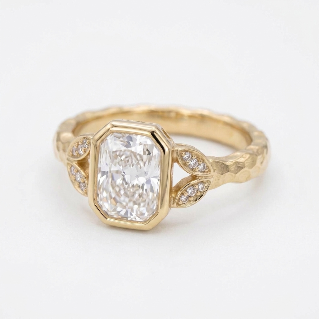 Angled view of a 3 CT radiant cut lab diamond bezel ring with pave leaf side accents in yellow gold.