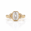 Overhead view of a 3 CT radiant cut lab grown diamond bezel setting on a hammered yellow gold band.