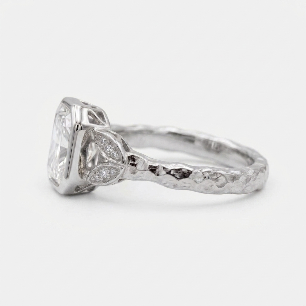 Side profile view of a 3 CT radiant cut lab diamond bezel setting in white gold with a textured hammered band.