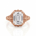 Direct top view of a 5 CT emerald cut lab grown diamond engagement ring in rose gold with vintage floral filigree shoulders.