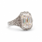 Angled side view of a 5 CT emerald cut lab diamond engagement ring in white gold with vintage filigree detail.