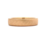 Front profile close-up view of a men's solid gold ring highlighting its diagonal wire-brushed surface texture.