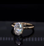 Angled top view of a 2 carat oval engagement ring revealing the sparkling diamond-accented hidden halo beneath the center stone.