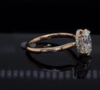 Side profile view of a gold engagement ring highlighting the exquisite hidden diamond halo holding a 2 CT oval cut diamond.