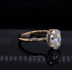 Angled profile shot of a 2 CT oval diamond ring emphasizing the elegant 4-prong setting and delicate diamond hidden halo against a black background.