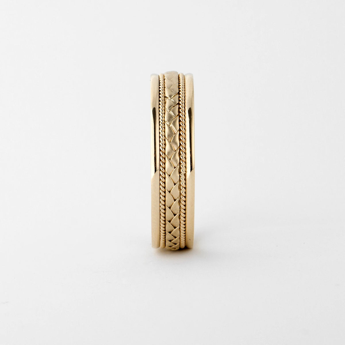 Vertical profile view displaying the intricate woven braid texture and polished outer edges of a men's gold band.
