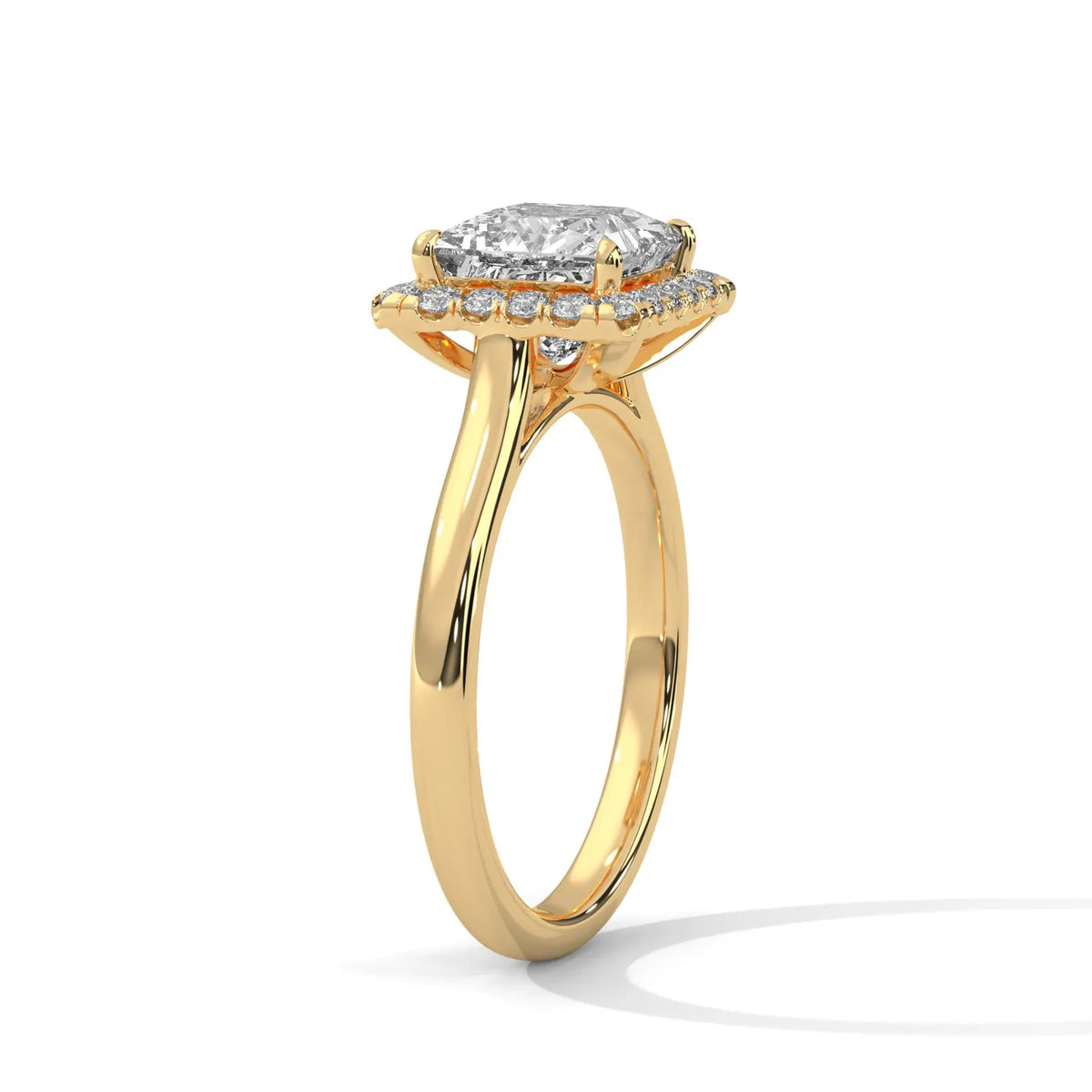 Three-quarter side angle of a 3 CT princess cut lab grown diamond engagement ring in yellow gold showing the under-halo setting.