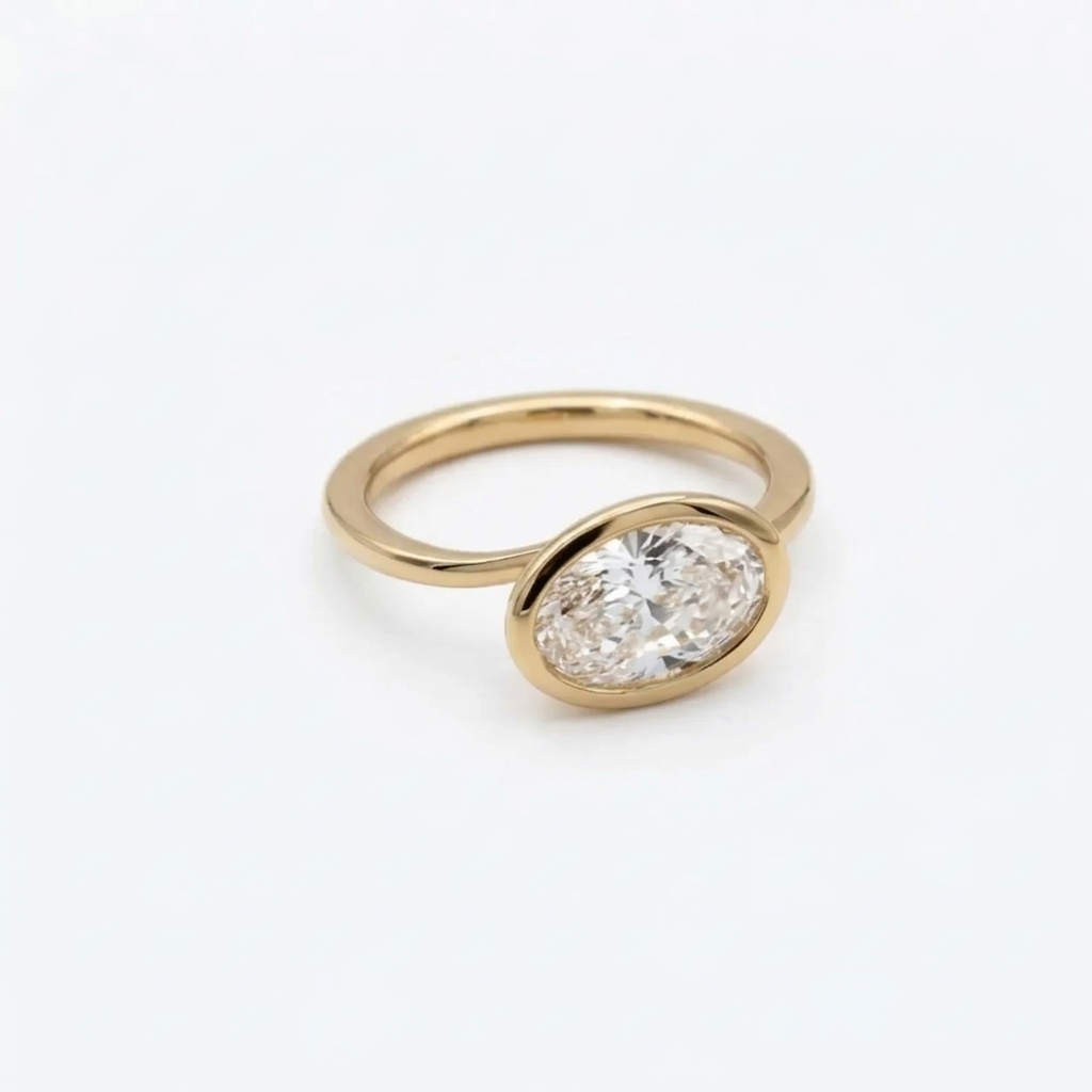 Three-quarter view of a 2 CT east-west oval cut lab grown diamond engagement ring set in a polished yellow gold bezel frame.