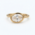 Top-down view of a 2 CT horizontal oval cut lab grown diamond solitaire set in a solid gold bezel frame.