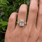 Top-down on-finger view of a 5 CT radiant cut lab diamond engagement ring with bezel-set trillion accents.