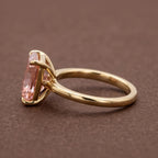 Side profile view of a 4 CT fancy pink radiant cut lab grown diamond engagement ring in yellow gold basket setting.