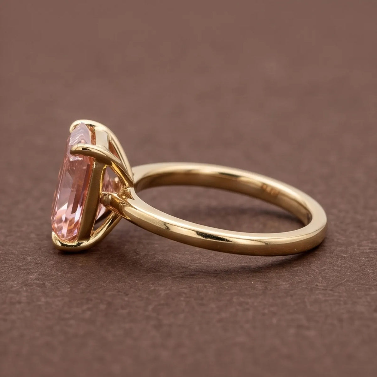 Side profile view of a 4 CT fancy pink radiant cut lab grown diamond engagement ring in yellow gold basket setting.