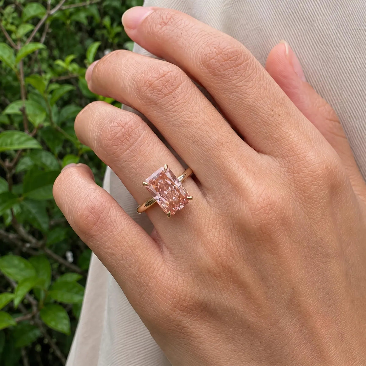 On-finger perspective of a 4 CT fancy pink radiant cut lab grown diamond solitaire ring.