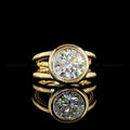 Front view with mirror reflection of a 4 CT round lab diamond bezel ring featuring a unique double split-shank band in yellow gold.