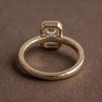 Bottom view of a 2 CT emerald cut lab grown diamond bezel engagement ring showing band architecture and undergallery.
