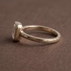 Side profile view showing the low-profile bezel setting and smooth rounded gold band of a 2 CT emerald diamond ring.