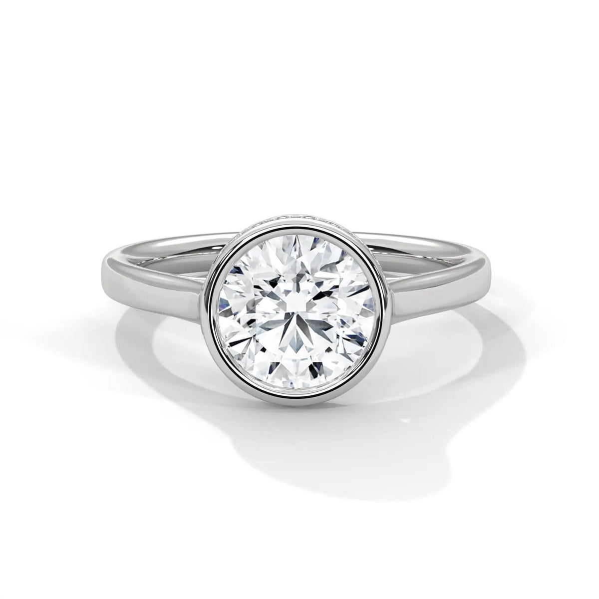 Top angle view of a 3 CT round cut lab grown diamond in a polished white gold bezel setting with diamond pavé rim.