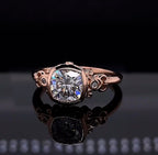 Direct top view of a 2 CT cushion cut lab grown diamond engagement ring featuring a vintage bezel setting and ornate rose gold scrollwork.