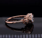 Side profile view of a vintage rose gold engagement ring showing intricate filigree details and a bezel-set cushion cut lab diamond.