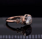 Three-quarter angled view of a 2 CT cushion cut lab grown diamond ring resting on a black reflective surface, showcasing its vintage band.