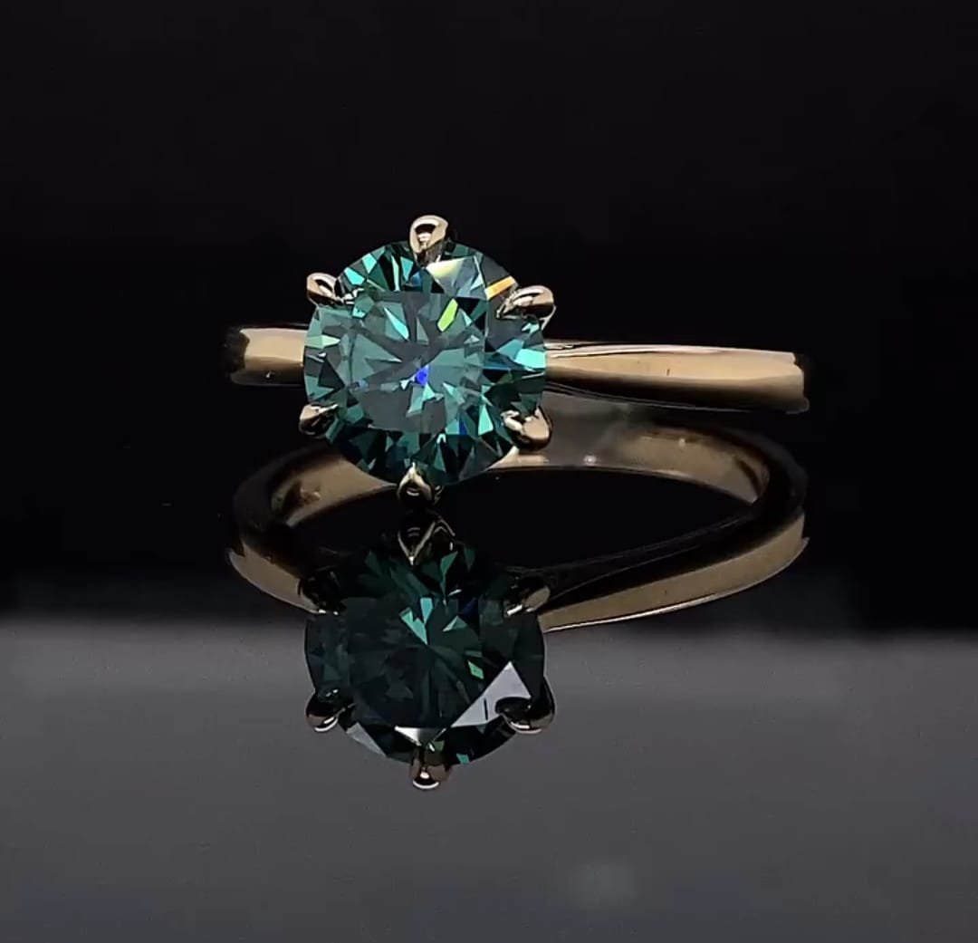 Top view of a 3 CT green round cut moissanite solitaire engagement ring in yellow gold
